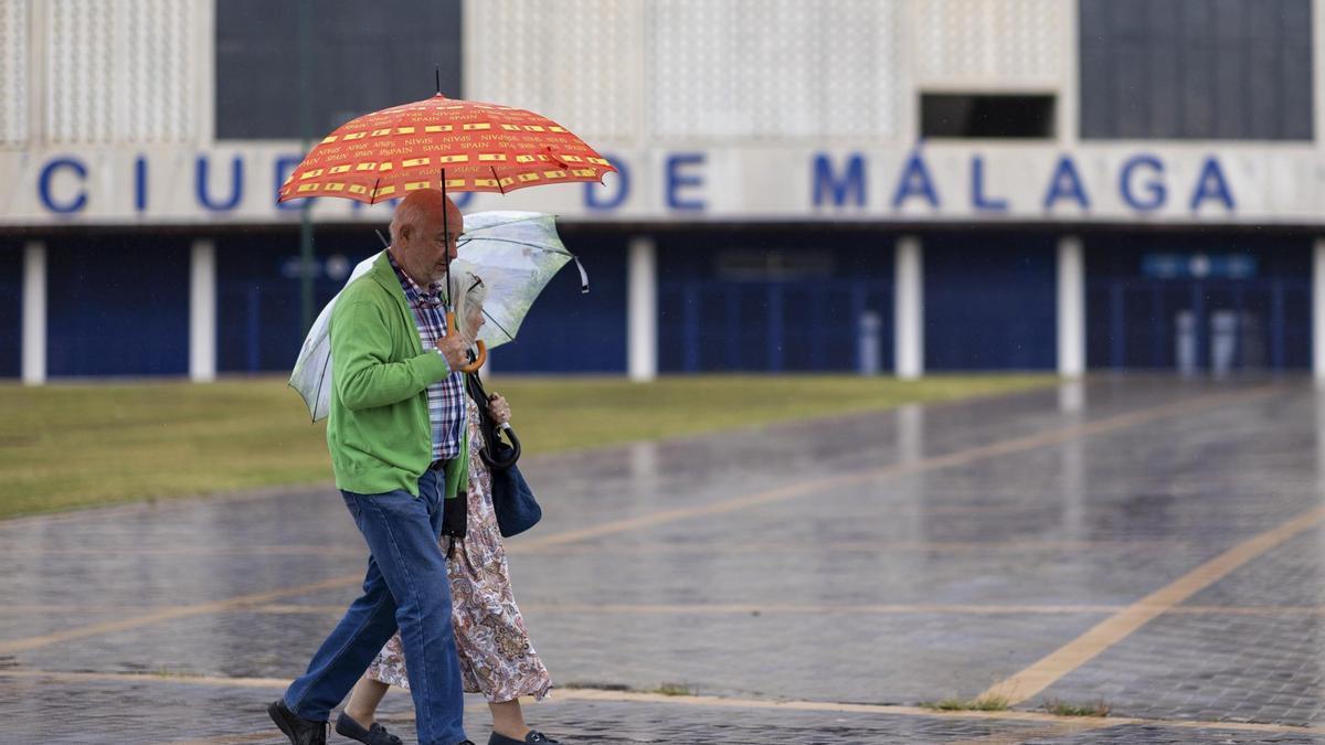 Dos personas caminando bajo la lluvia en Málaga