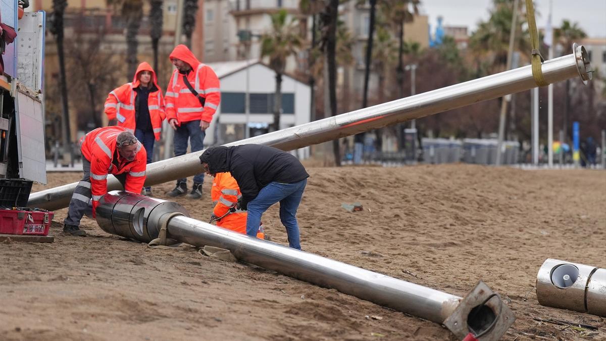 Operarios retiran las torres de megafonía de la playa de la Barceloneta durante el temporal, a 19 de enero de 2026, en Barcelona.