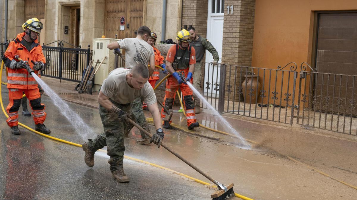 Miembros del Ejército de Tierra limpia las calles tras el paso de la DANA en Utiel.