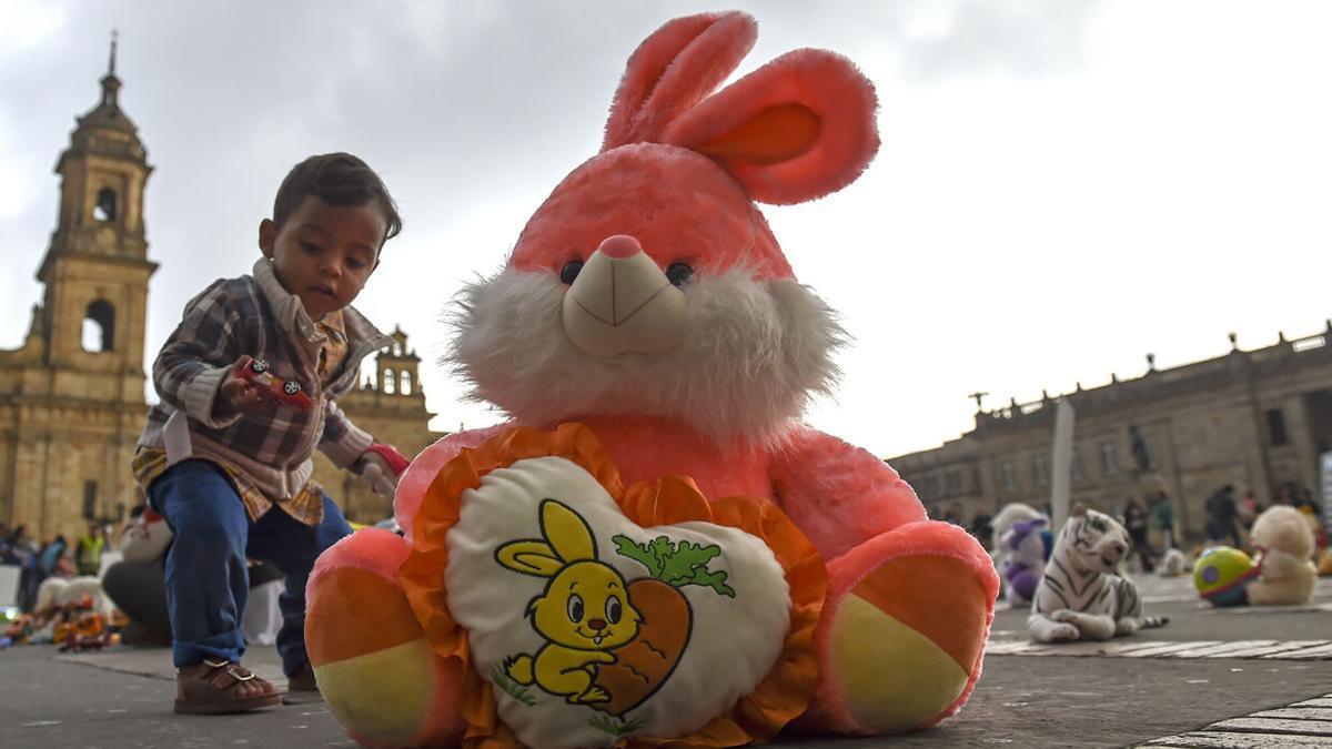 Un niño jugando junto a un peluche durante un acto de protesta contra el abuso infantil.