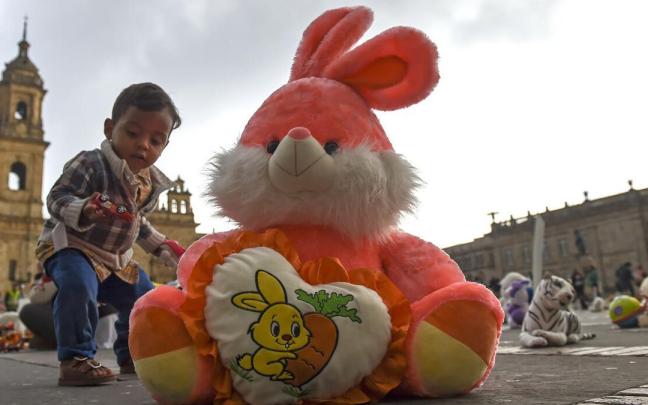 Un ni&ntilde;o jugando junto a un peluche durante un acto de protesta contra el abuso infantil.