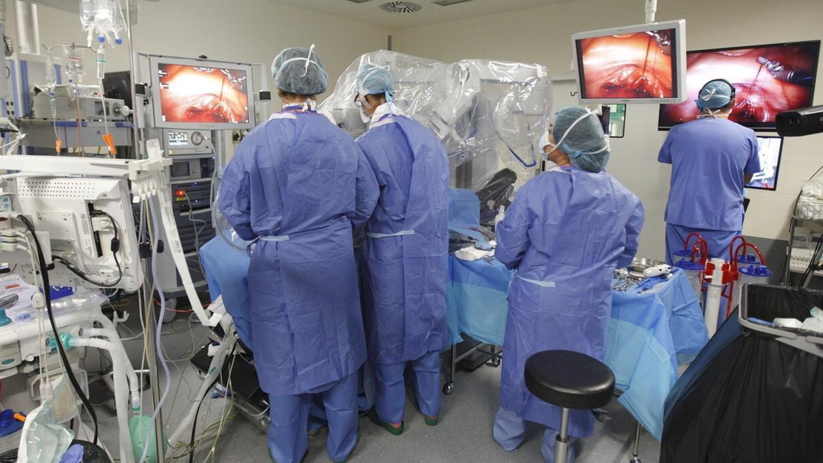 Varios cirujanos realizan una intervención con moderna tecnología.