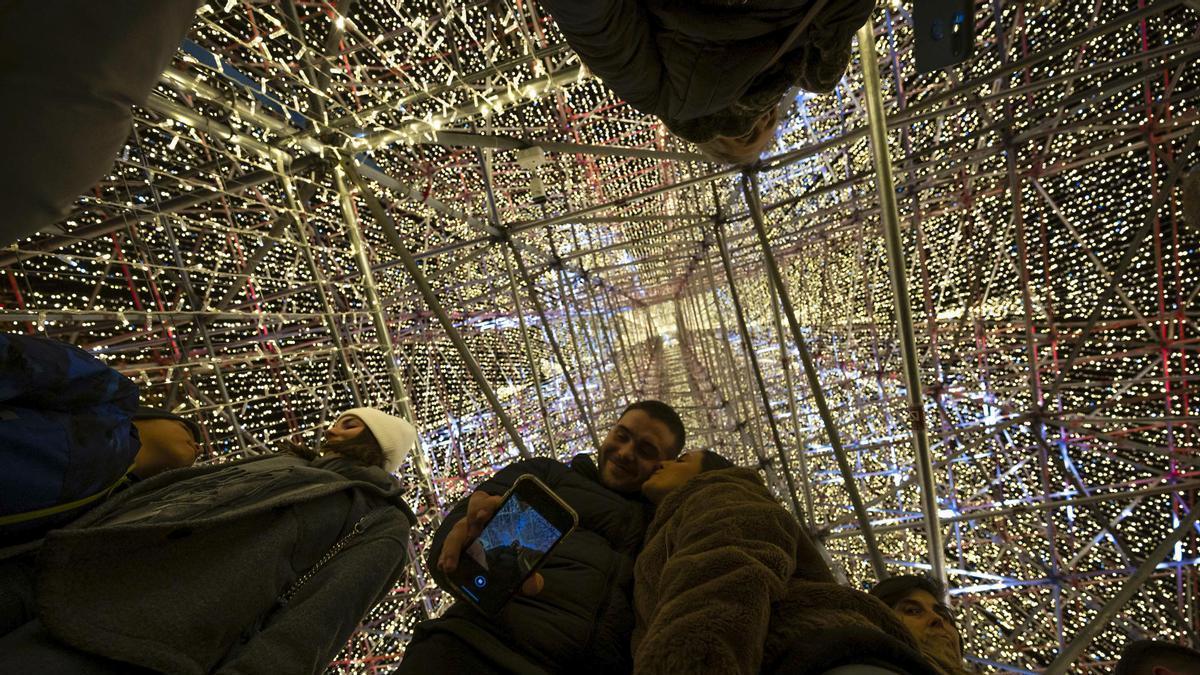 Varias personas se hacen un selfie debajo del árbol de Navidad de Cartes.