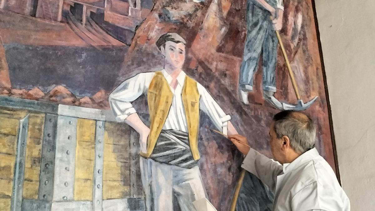 Ángel Aja retoca una parte del mural que preside el hall de acceso a la ermita de Santa Bárbara.