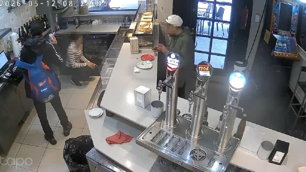Un momento del vídeo en el que uno de los ladrones amenaza a la camarera con la supuesta botella con ácido.