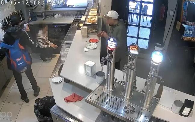 Un momento del vídeo en el que uno de los ladrones amenaza a la camarera con la supuesta botella con ácido.