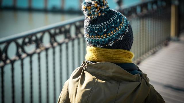 Un niño abrigado con gorro y bufanda.