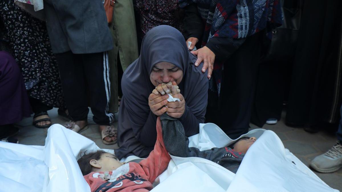 Una madre llora antes sus dos hijos muertos en un bombardeo israelí sobre Gaza.