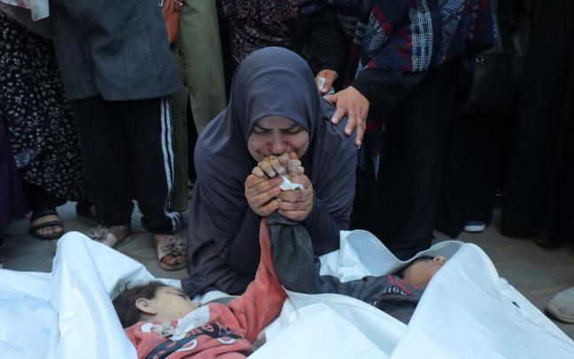 Una madre llora antes sus dos hijos muertos en un bombardeo israelí sobre Gaza.