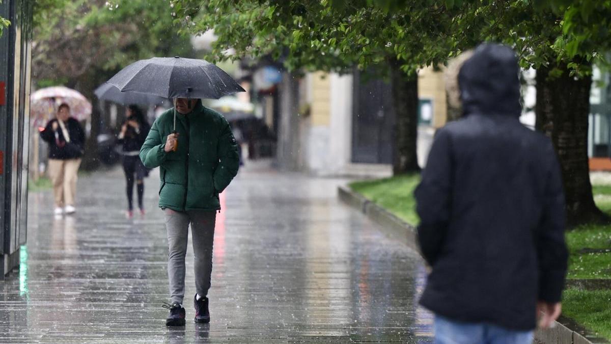 Varias personas caminan bajo la lluvia en una foto de archivo.