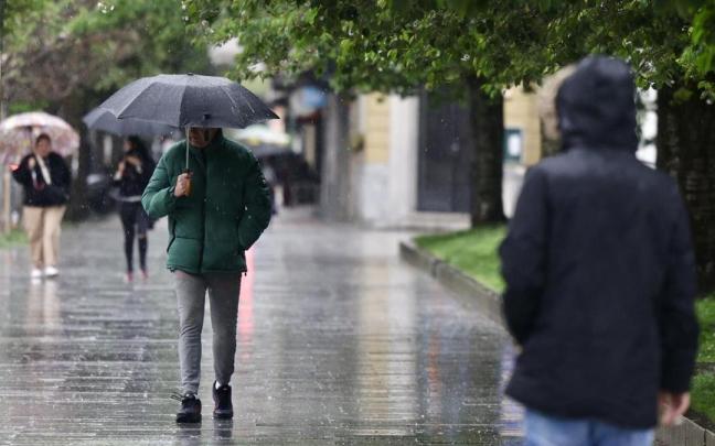 Varias personas caminan bajo la lluvia en una foto de archivo.