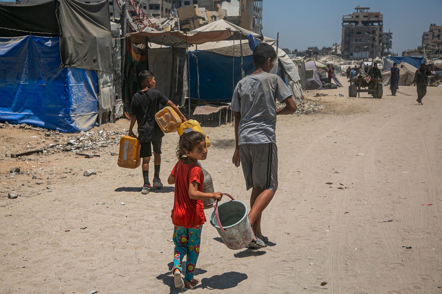 Varios niños buscan agua en un campamento de refugiados al oeste de la ciudad de Gaza.