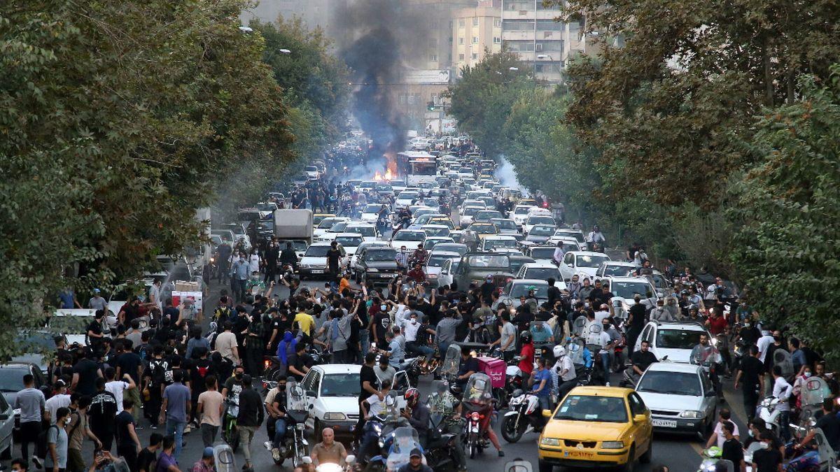 Un grupo de personas se enfrenta a la policía durante una protesta por la muerte de Mahsa Amini, en Teherán