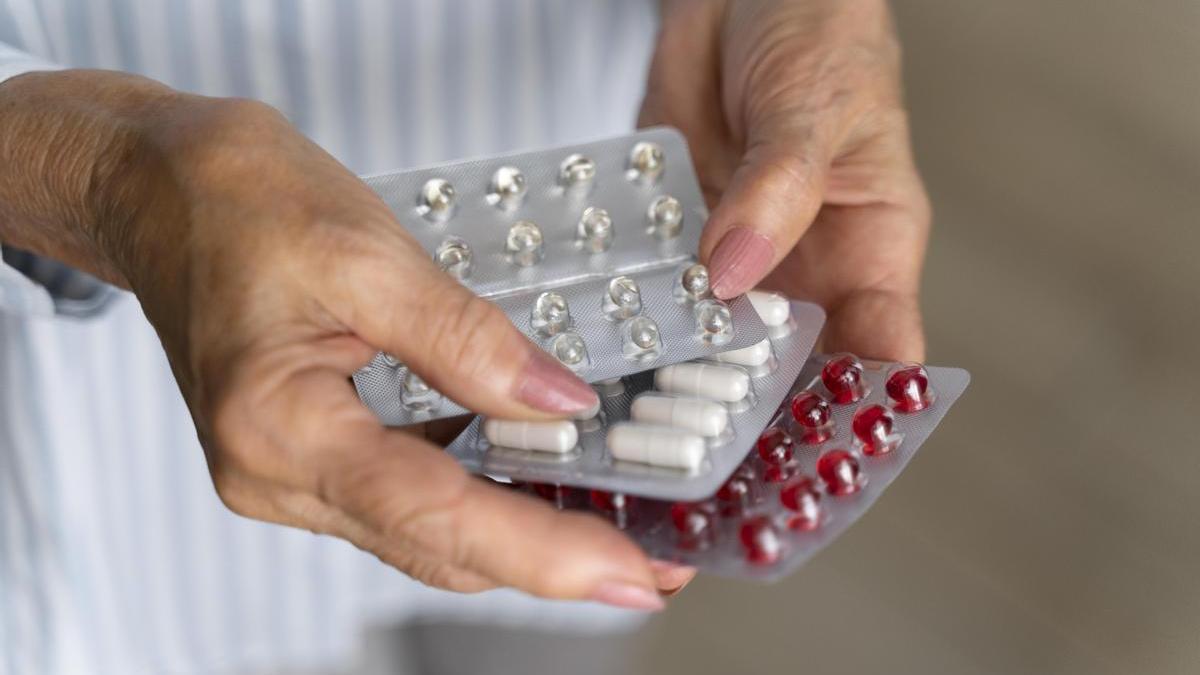 Una mujer sostiene varias pastillas entre sus manos.