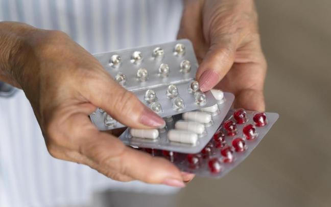 Una mujer sostiene varias pastillas entre sus manos.