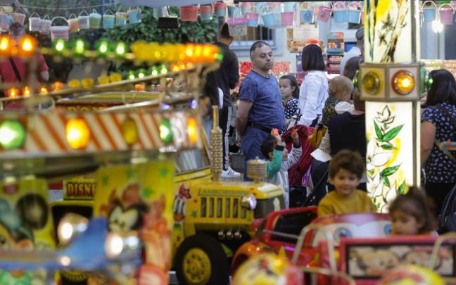 Varias personas en las atracciones de una feria.