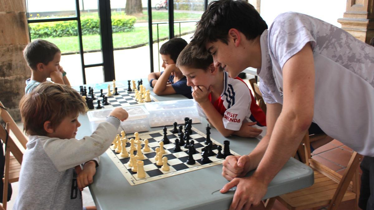 Markel enseña a dos niños a mover las fichas en el tablero.