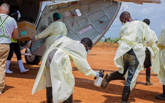 Personal sanitario con trajes de protección realiza labores de desinfección antes de transportar suministros médicos para combatir la epidemia de ébola en Mongbwalu, Ituri.