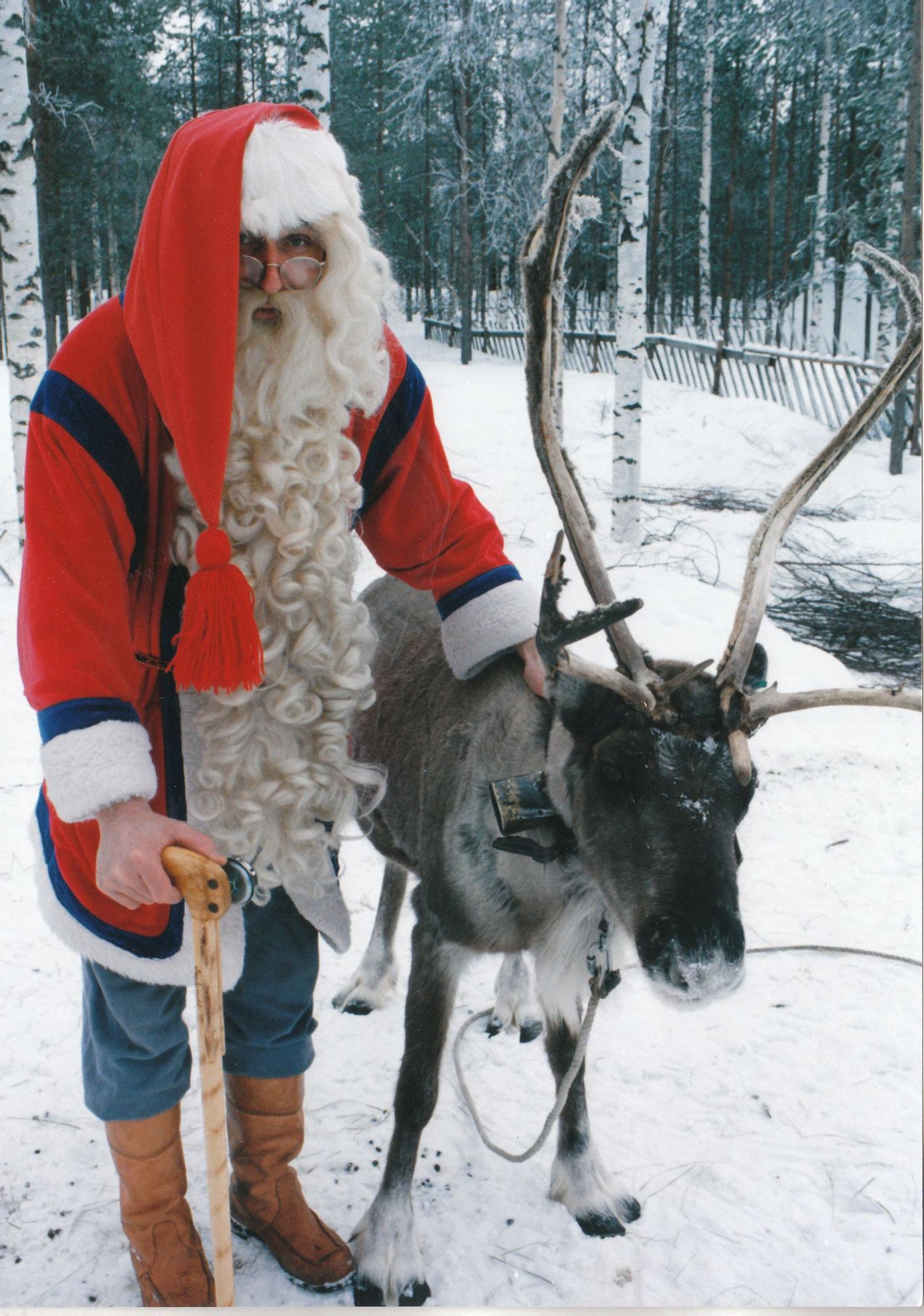 Papá Noel, posando con el reno Rudolf.