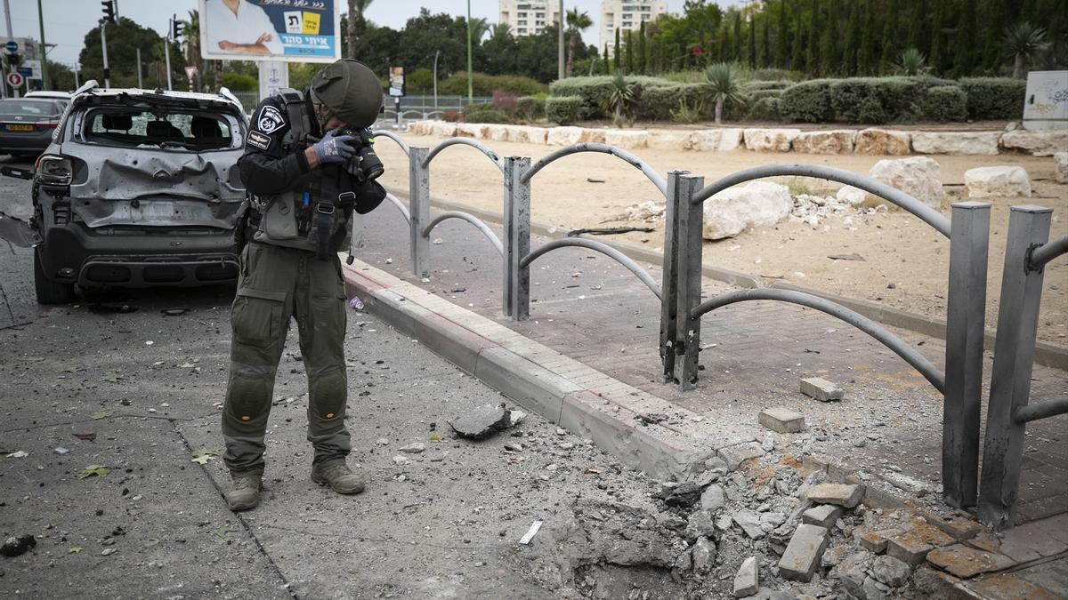 Un agente de la Policía israelí fotografía los daños causados por los misiles en Ascalón.