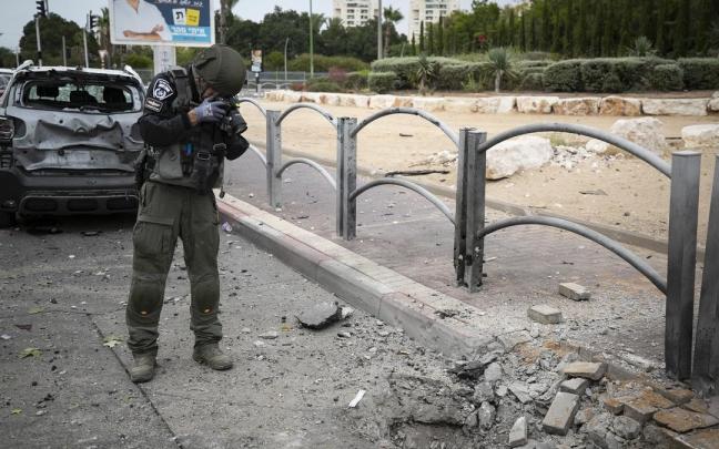 Un agente de la Policía israelí fotografía los daños causados por los misiles en Ascalón. Un agente de la Policía israelí fotografía los daños causados por los misiles en Ascalón.