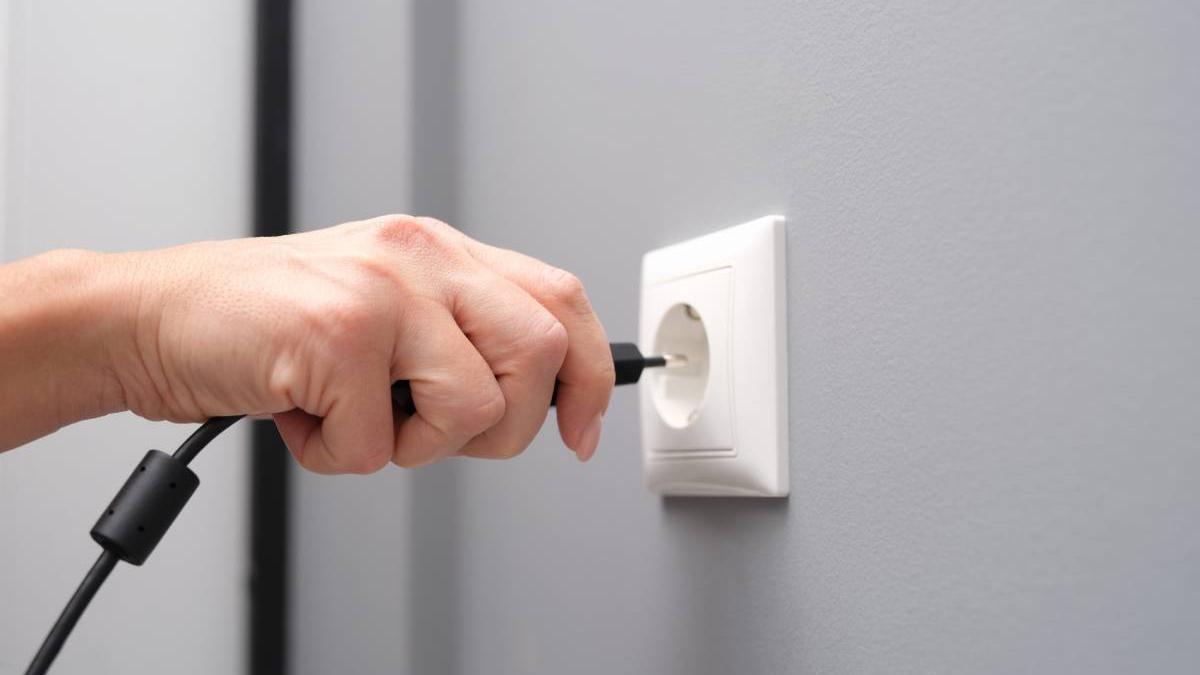 Manos desenchufan un cable.