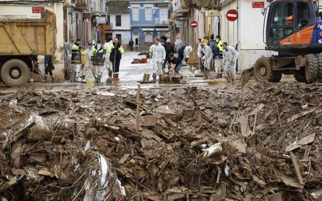 Voluntarios siguen en labores de limpieza ante una montaña de escombros en Paiporta.
