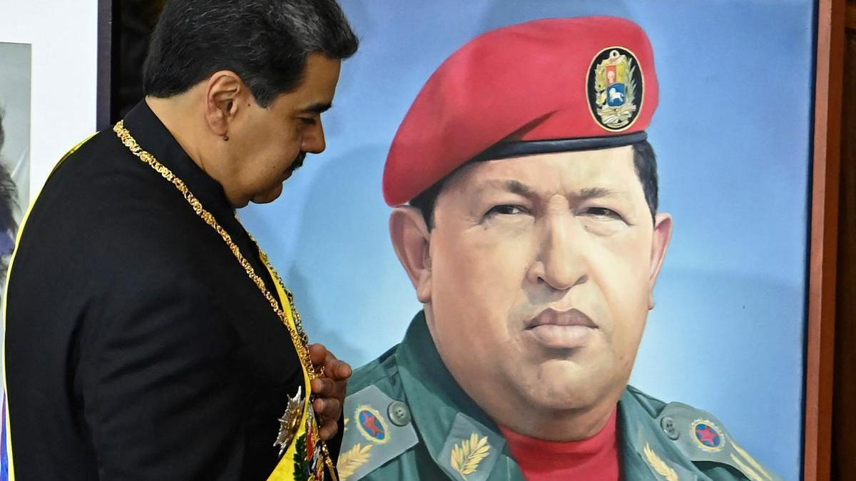 Nicolás Maduro posa ante un retrato de Hugo Chávez.