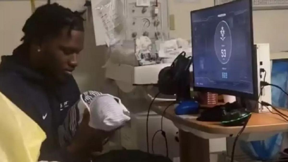 El joven, con su bebé en brazos frente al equipo de gaming.