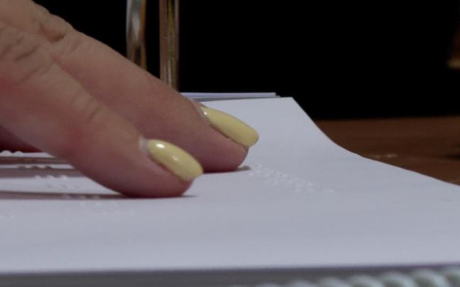 Una mujer ciega leyendo Braille