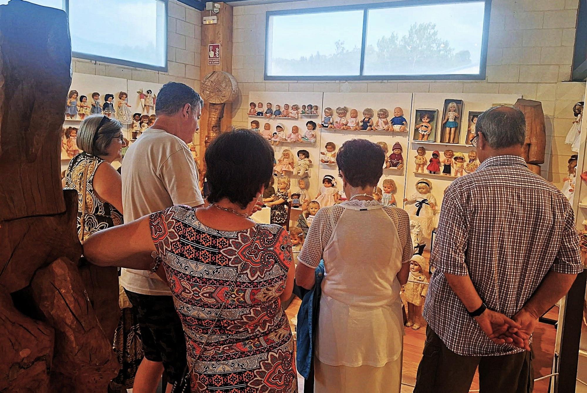 Visitantes en la muestra de muñecas, instalada entre esculturas de Xabier Santxotena