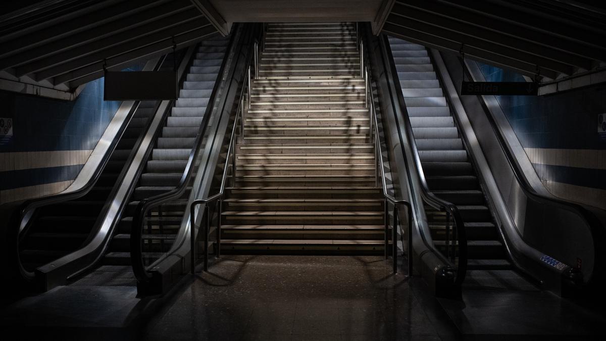 Escaleras de una estación de Metro iluminadas con las luces de emergencia.