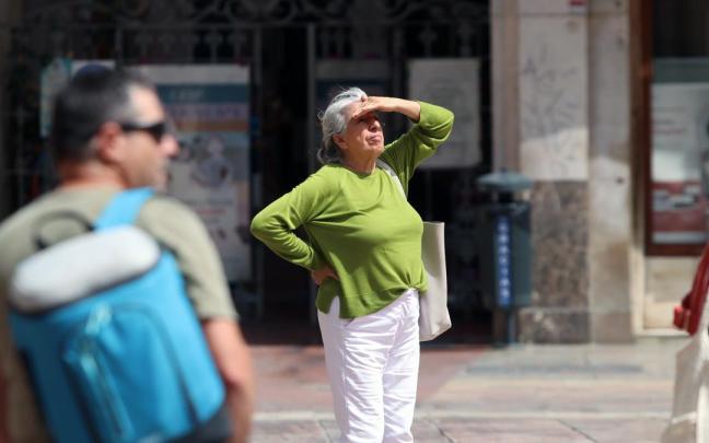 Viandantes soportan las altas temperaturas por las calles de Málaga.