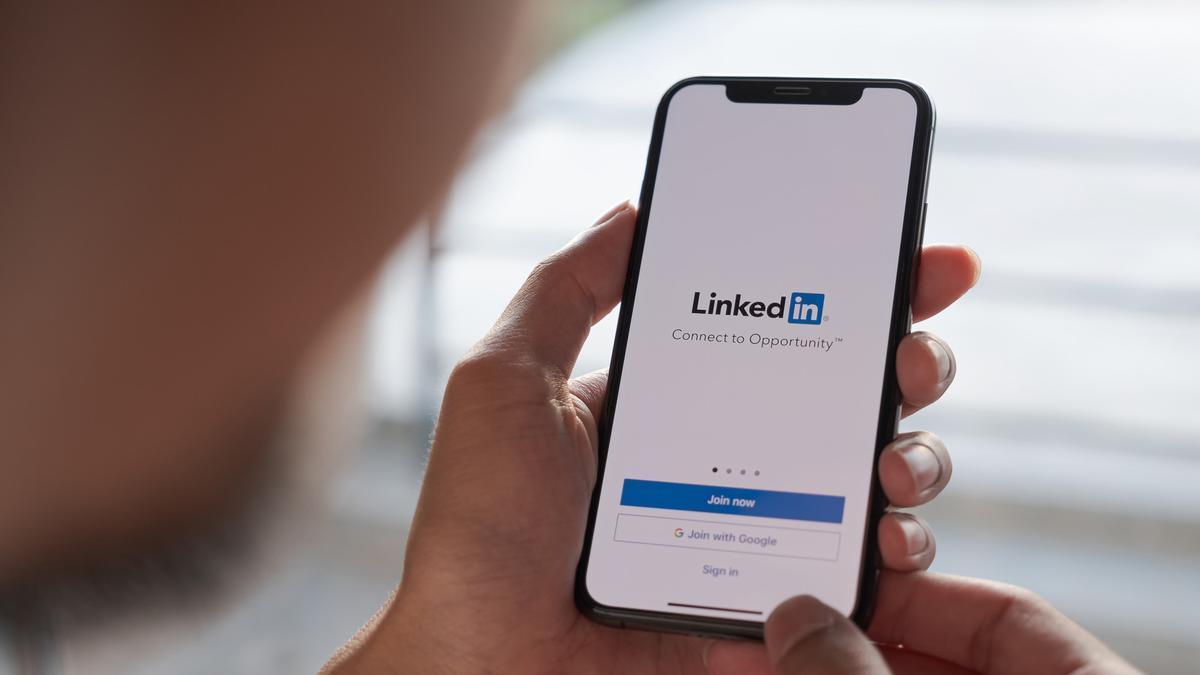 Un hombre abre la aplicación de LinkedIn en su móvil.