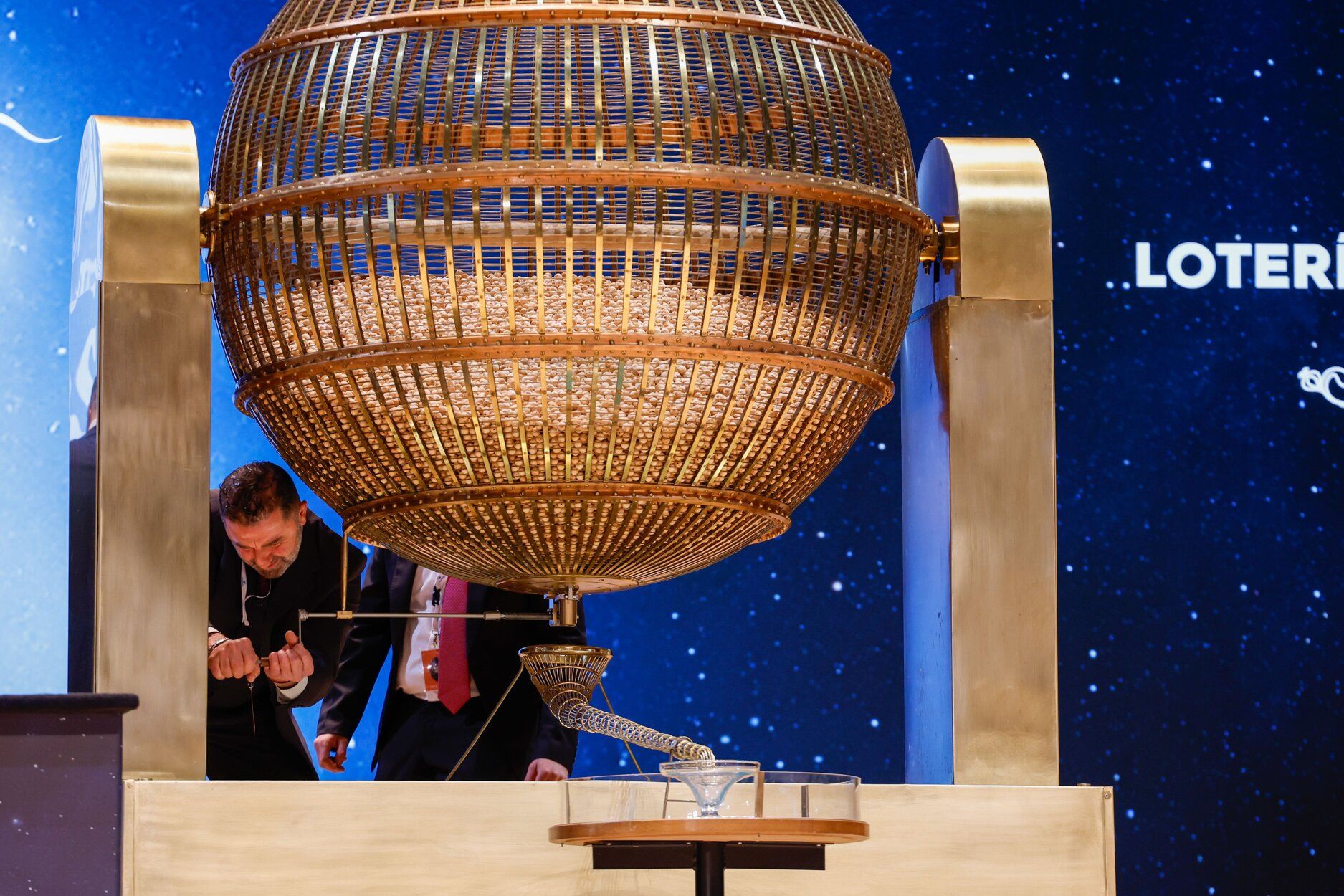 Un responsable revisa uno de los bombos en un sorteo de la Lotería de Navidad.