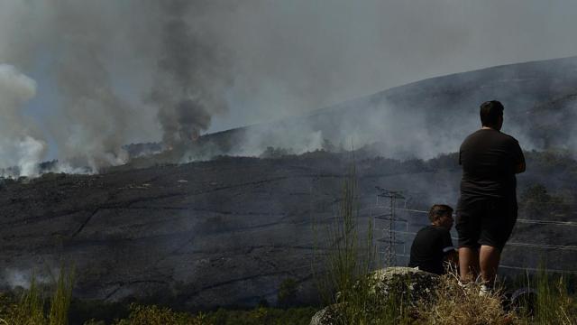 Imagen de archivo de dos personas contemplando los incendios en Galicia en 2022.