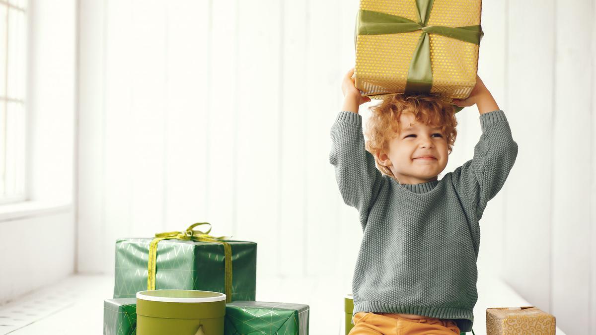 Un niño sostiene ilusionado una caja de regalo.