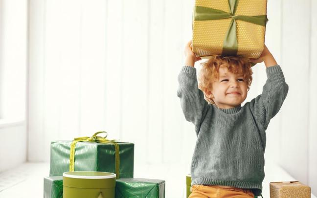 Un niño sostiene ilusionado una caja de regalo.
