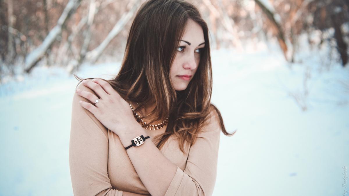 Una mujer posa en un bosque nevado.