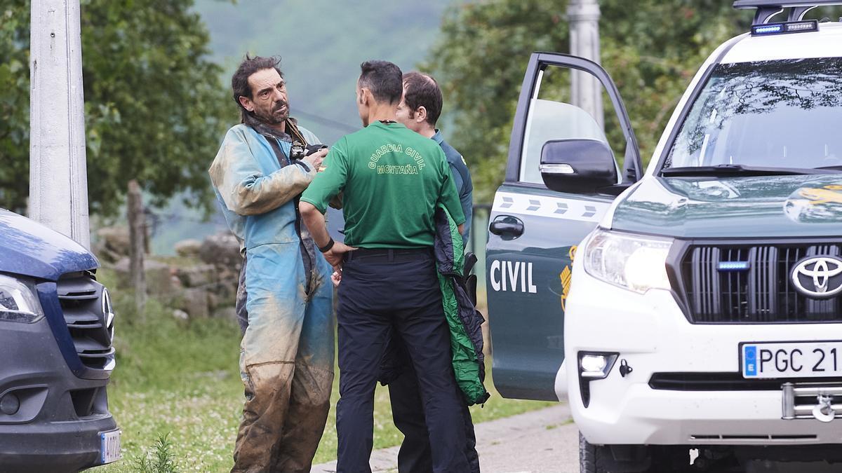 Uno de los espeleólogos rescatados habla con dos agentes tras salir de la cueva por su propio pie.