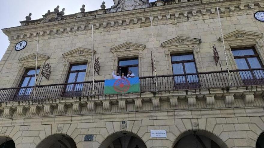 Representantes de distintas asociaciones cuelgan la bandera del pueblo gitano en el Ayuntamiento de Irun