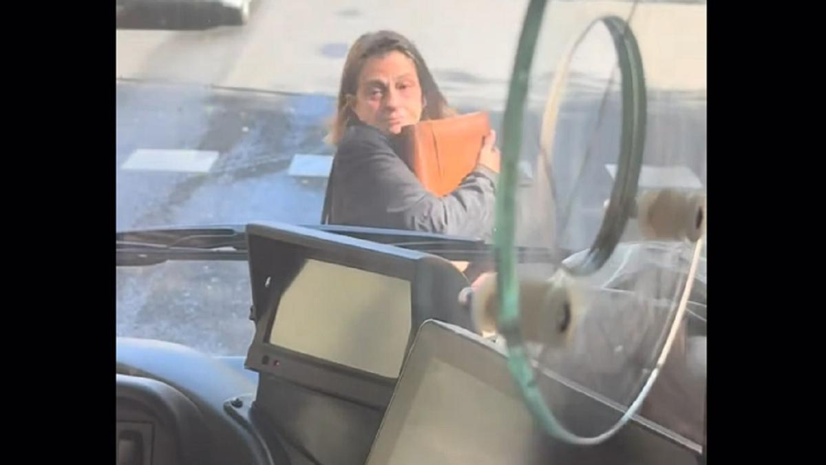 La mujer, delante del autobús.