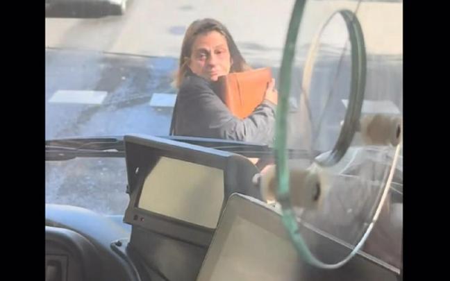 La mujer, delante del autobús.