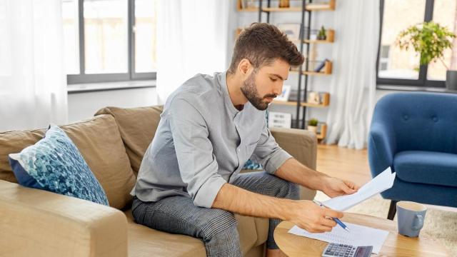 Un hombre hace cuentas sobre una posible futura hipoteca.