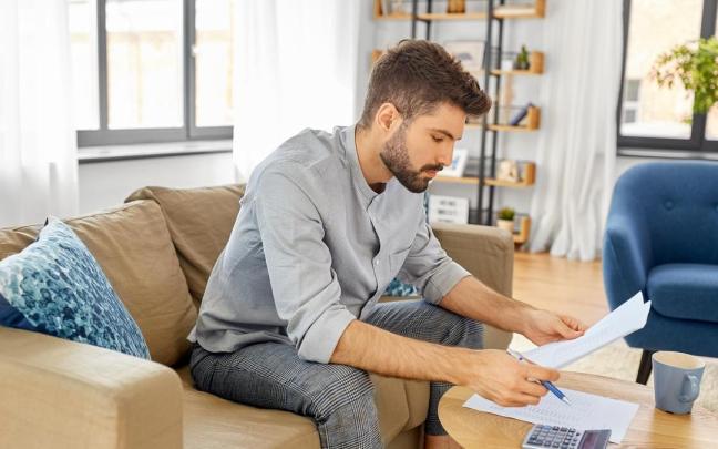 Un hombre hace cuentas sobre una posible futura hipoteca.