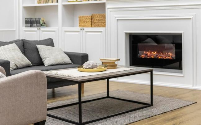 Una chimenea con un cristal protector en un salón de estar.