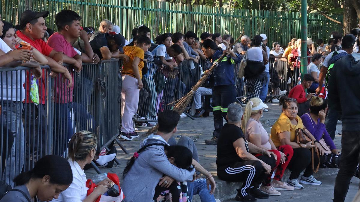 Personas hacen fila para resolver su situación migratoria este miércoles