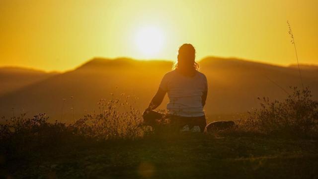 Una mujer observa una puesta de Sol desde Olarizu, en Gasteiz.