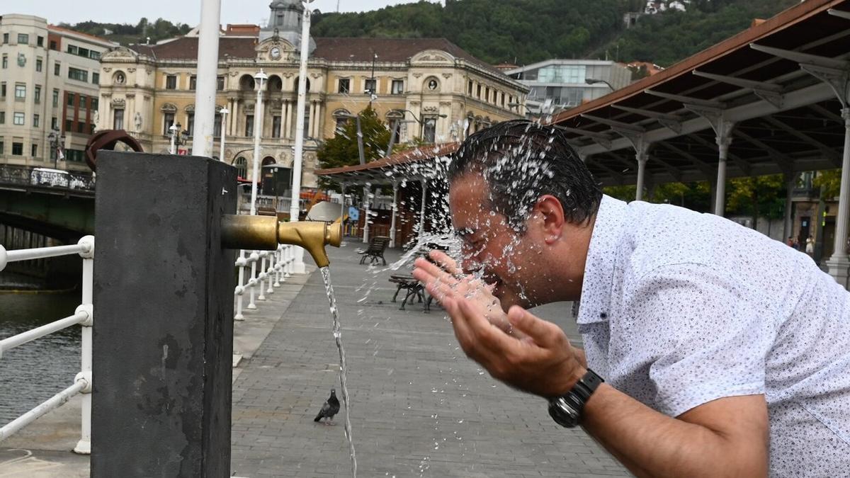 Un hombre se refresca en una fuente de Bilbao. Foto: Oskar González