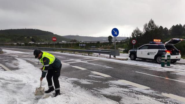 Un agente de la Guardia Civil retira granizo de la calzada con una pala. Redacción DNN Un agente de la Guardia Civil retira granizo de la calzada con una pala. Redacción DNN
